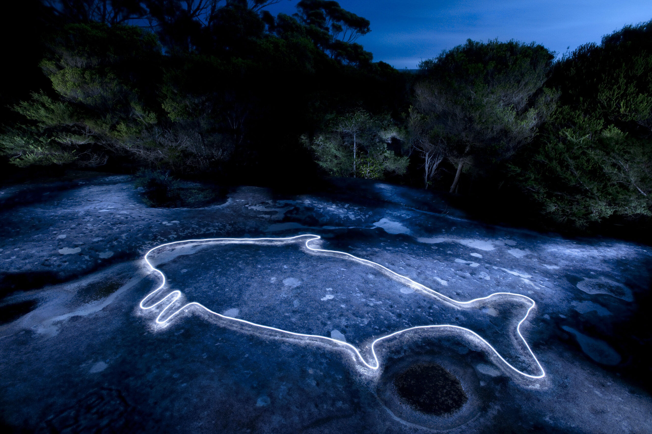 Rock engravings traced with light at night